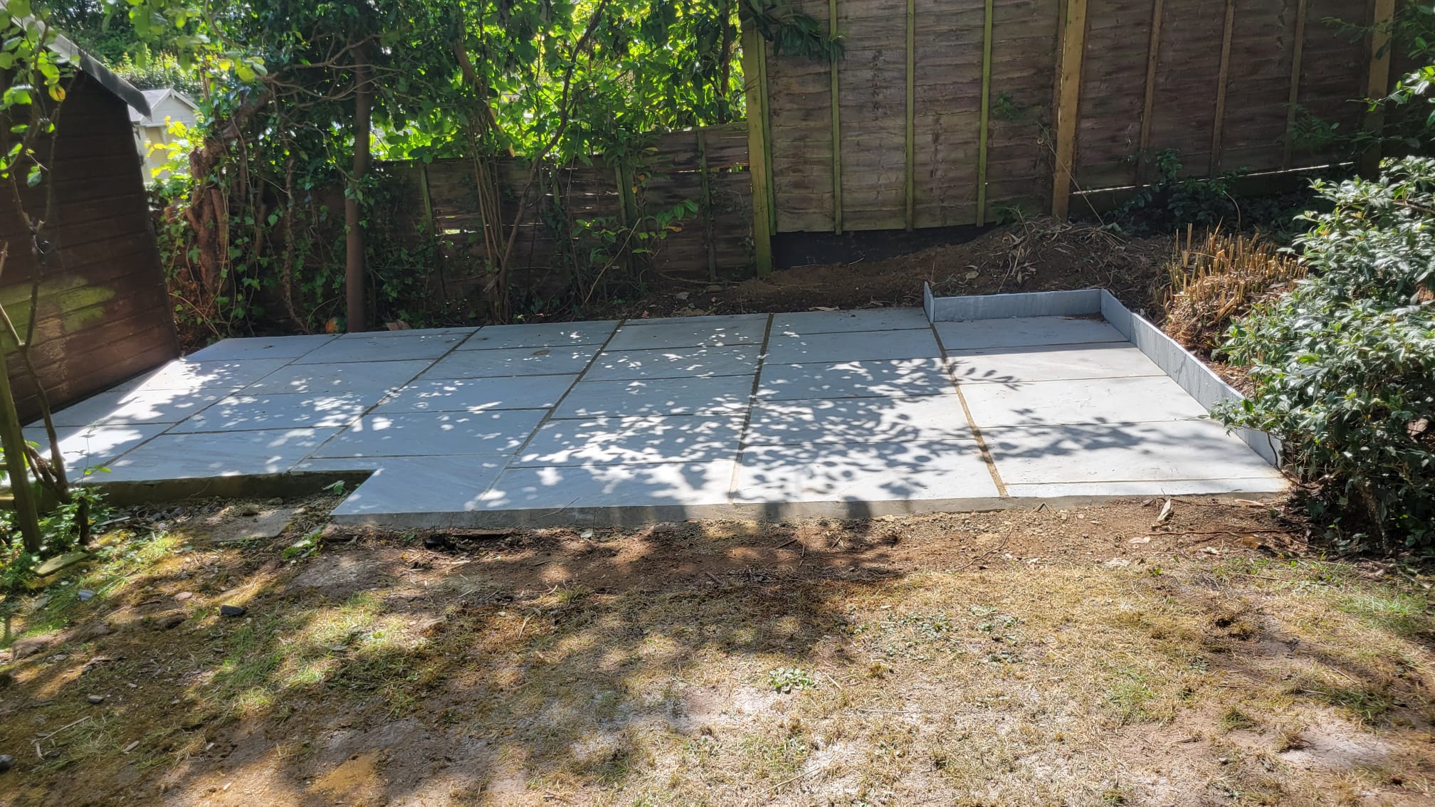 Finished grey stone patio after landscaping